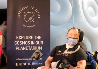 image shows Ricky, a person supported by PHSS in front of the planetarium dome