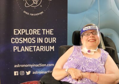 image shows Chelsey, a person supported by PHSS smiling in front of the planetarium dome