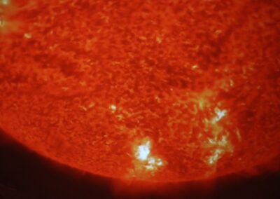 image shows a bright red sun with solar flares